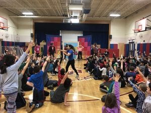 Story Pirates with CLE students raising hands in gym