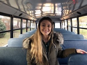 Teacher smiling standing inside bus