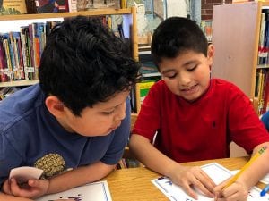 Two boys working on word puzzle