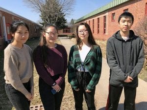 Four students standing in courtyard