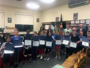 Group of students with certificates and district administrators