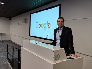 TZHS alumnus Edward Forgacs standing at white podium with Google sign behind him