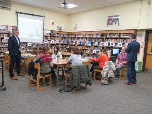 SOMS administrators, standing, speak to small group of seated parents in library