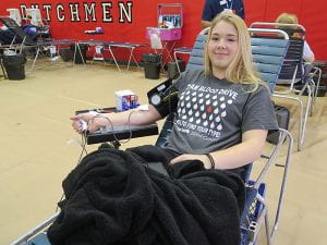 Female student reclining on chaise giving blood