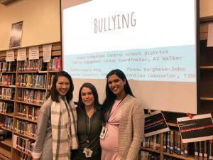 School Prevention Counselors and FEC Coordinator in SOMS library with "Bullying" presentation on screen