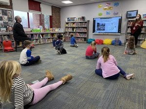 Students sitting on floor looking at smartboard