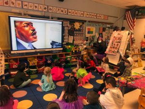 Kindergarten students viewing an image from "Let the Children March"