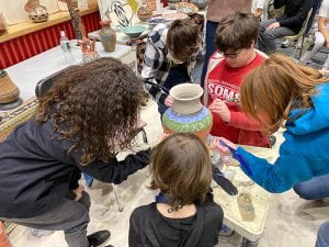 SOMS students carve designs in clay vase