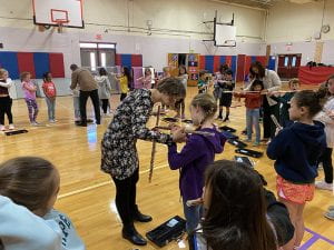 Christina Hughes helps student with flute