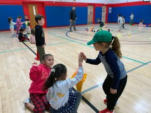 K-2 students giving high-five in PE class